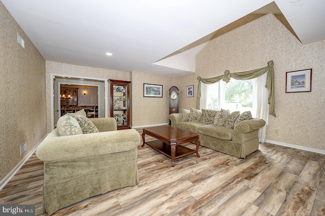 living room featuring lofted ceiling and hardwood / wood-style flooring