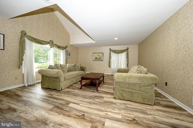 living room featuring lofted ceiling and hardwood / wood-style flooring