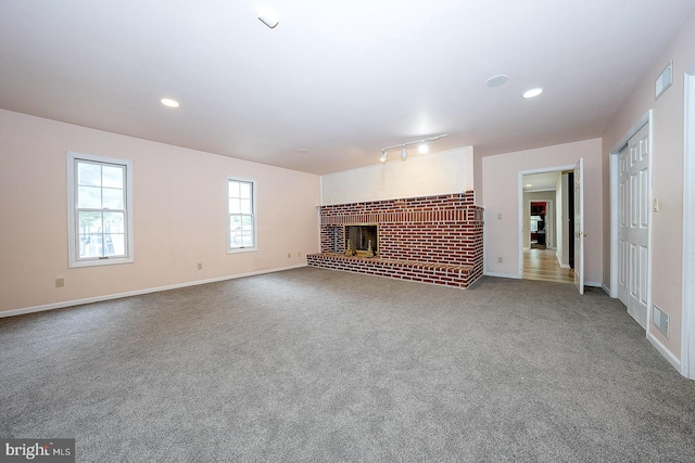 unfurnished living room with carpet floors and a fireplace