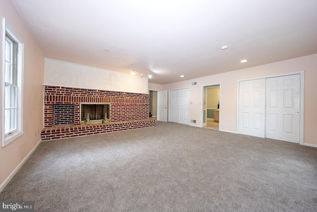 unfurnished living room with carpet and a brick fireplace