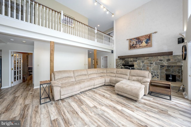 living room featuring a towering ceiling, hardwood / wood-style floors, and rail lighting