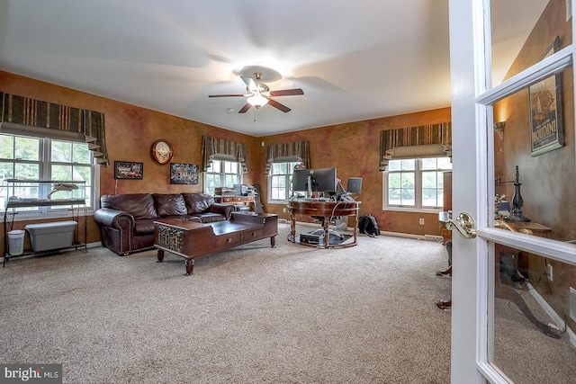 living room featuring ceiling fan, carpet, and a wealth of natural light