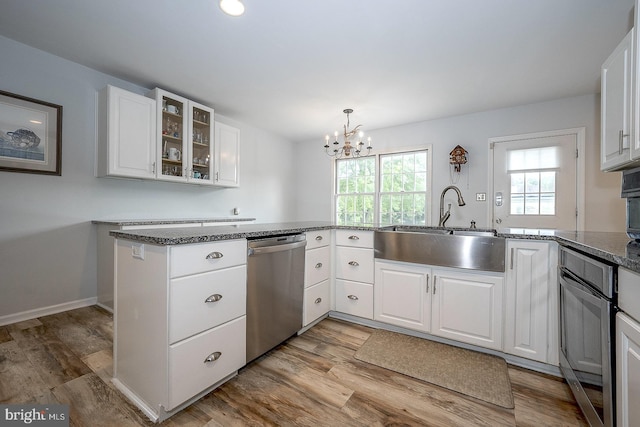 kitchen with white cabinetry, kitchen peninsula, stainless steel dishwasher, and light hardwood / wood-style floors