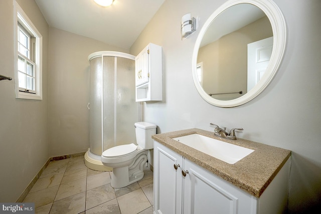 bathroom featuring vanity, a shower with shower door, and toilet