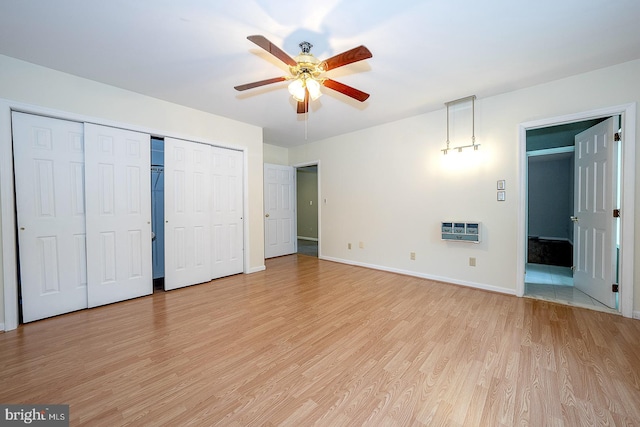 unfurnished bedroom featuring light hardwood / wood-style floors, heating unit, and ceiling fan