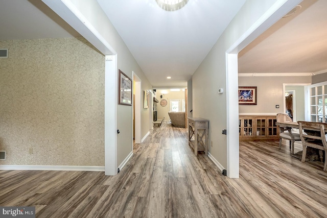 hallway with crown molding and hardwood / wood-style flooring