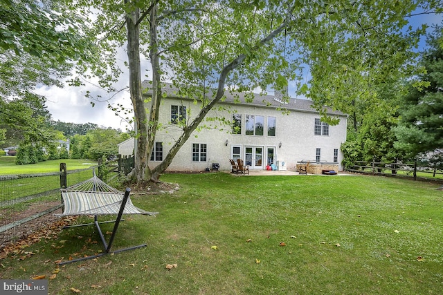 rear view of property with a patio and a lawn