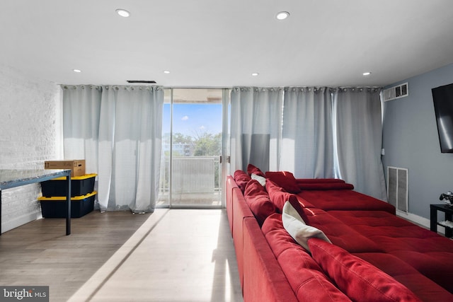 bedroom with recessed lighting, wood finished floors, visible vents, access to exterior, and expansive windows