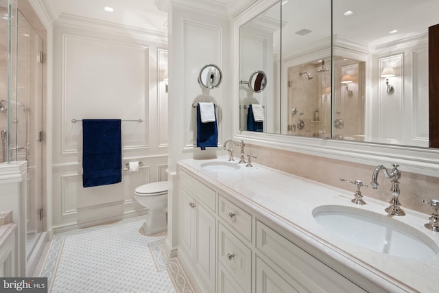 bathroom with vanity, tile patterned floors, toilet, ornamental molding, and a shower with shower door