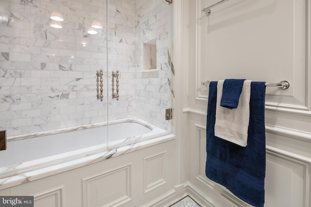 bathroom featuring combined bath / shower with glass door