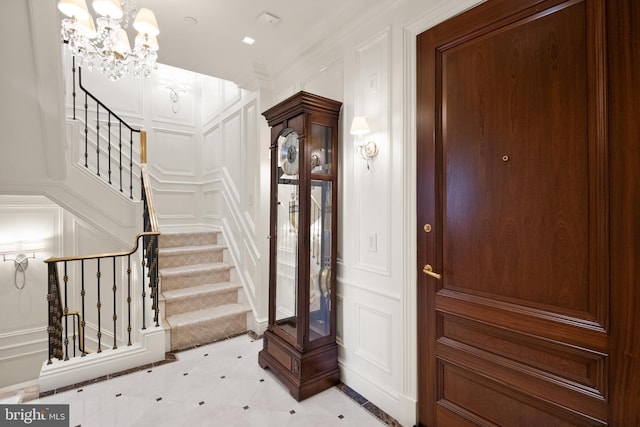 foyer with a chandelier and ornamental molding