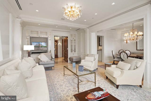 living room featuring light hardwood / wood-style floors, crown molding, and a notable chandelier