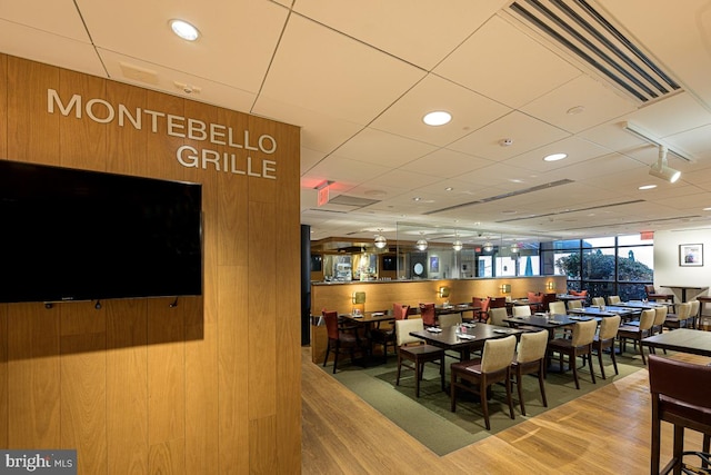 dining space featuring wooden walls and wood-type flooring