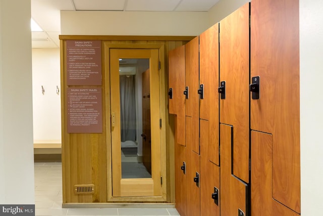 interior space featuring light tile patterned floors and a paneled ceiling