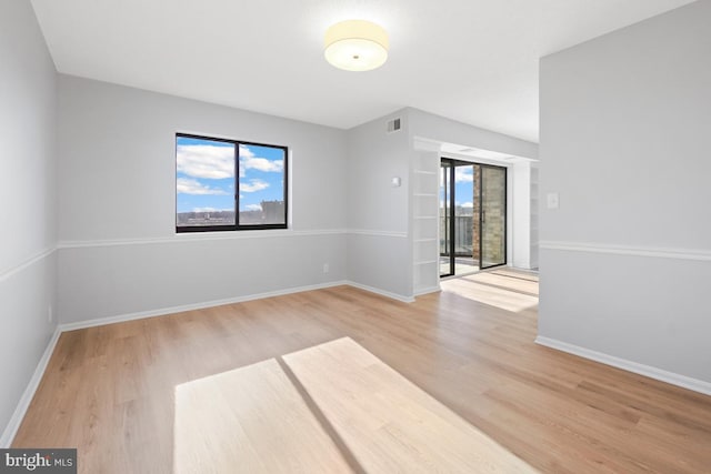 spare room with hardwood / wood-style flooring and a wealth of natural light