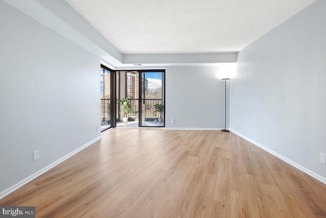 unfurnished room featuring a textured ceiling and light wood-type flooring