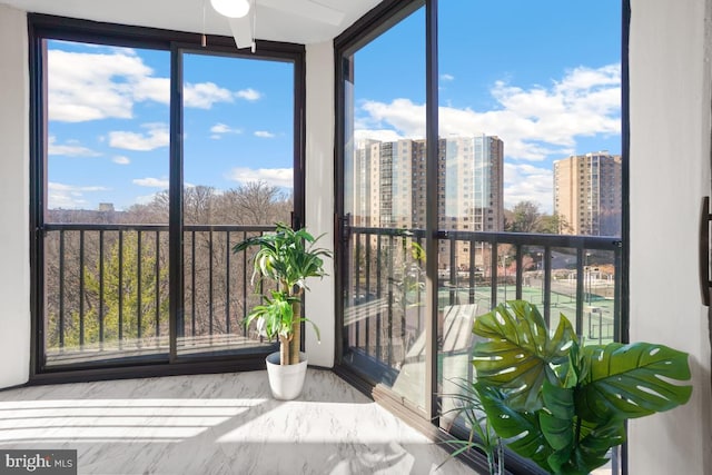 unfurnished sunroom with ceiling fan