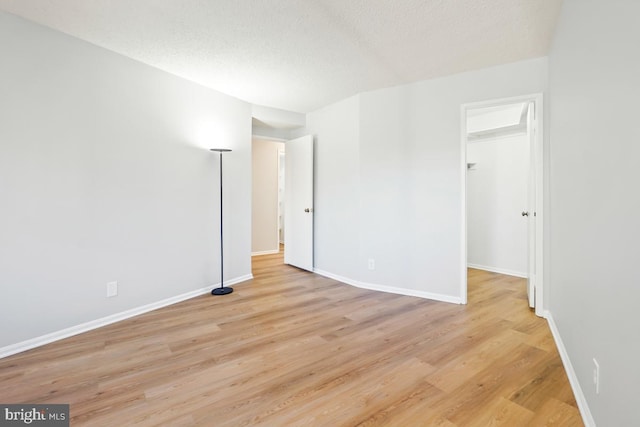 spare room featuring light hardwood / wood-style flooring and a textured ceiling