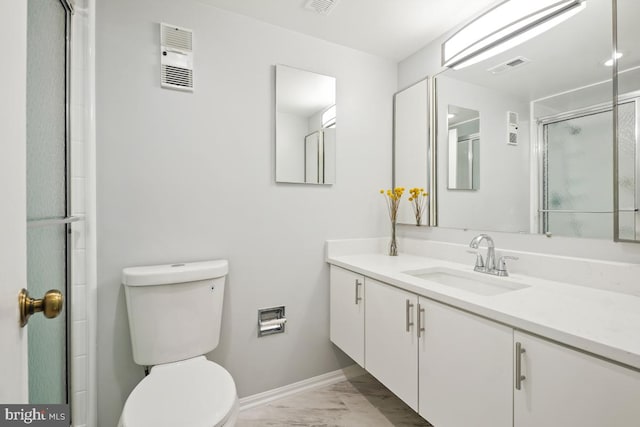 bathroom with vanity, toilet, and a shower with shower door