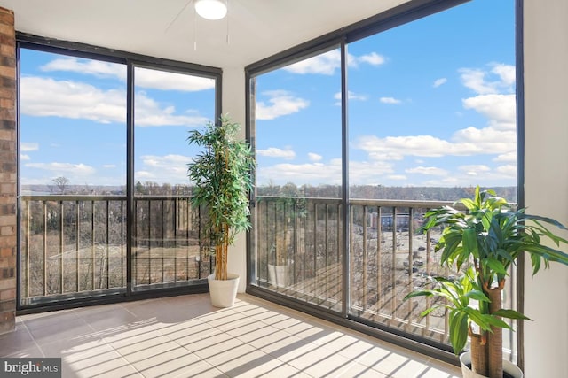 unfurnished sunroom with ceiling fan