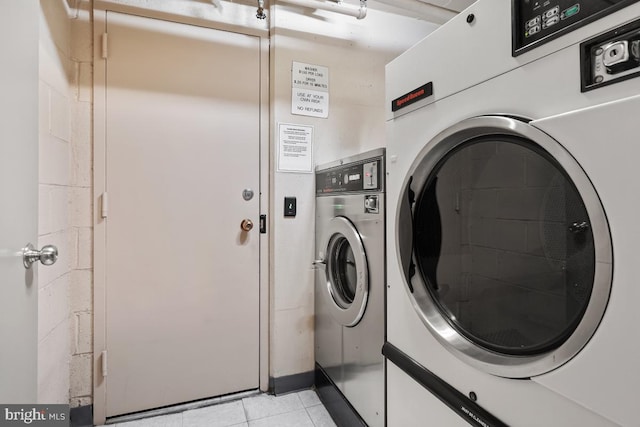 washroom with independent washer and dryer and light tile patterned flooring