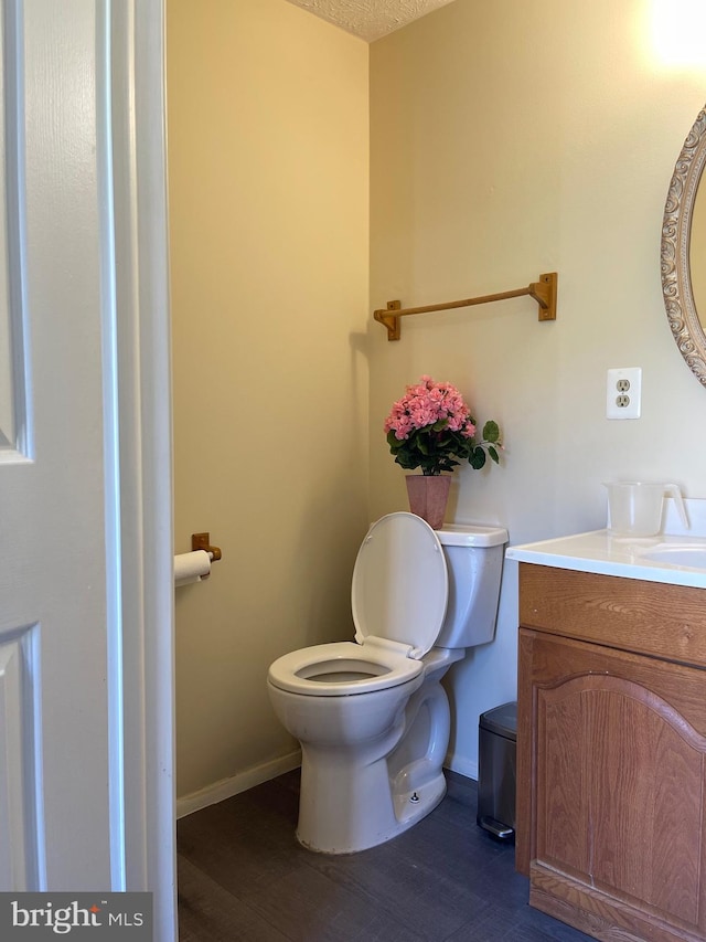 bathroom featuring vanity, toilet, and hardwood / wood-style floors