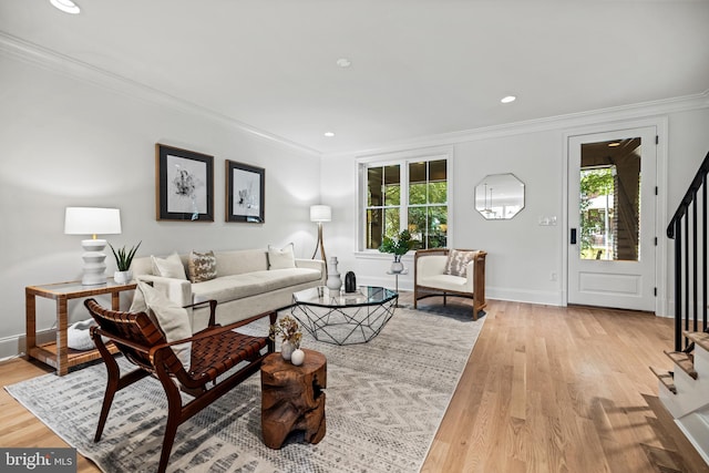 living room featuring crown molding, plenty of natural light, and light wood-type flooring