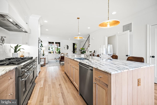 kitchen with a kitchen island with sink, pendant lighting, light hardwood / wood-style flooring, stainless steel appliances, and custom range hood