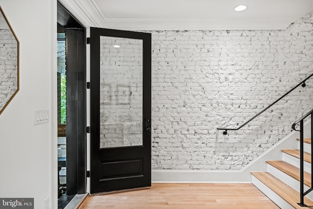 foyer featuring ornamental molding and light hardwood / wood-style floors