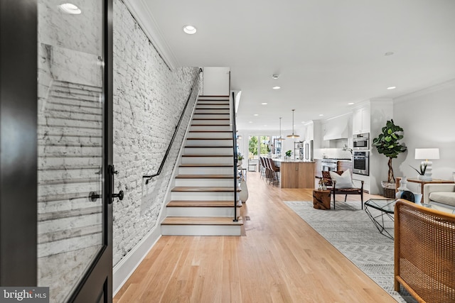 stairway featuring crown molding and hardwood / wood-style flooring