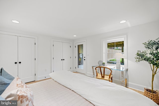 bedroom featuring light wood-type flooring and two closets