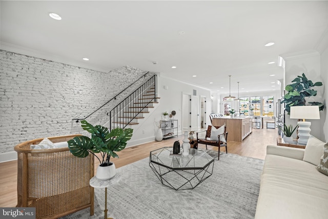 living room with light wood-type flooring and crown molding