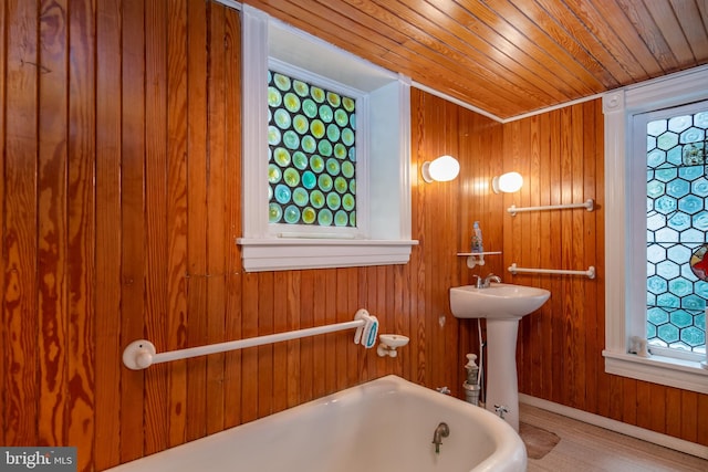 bathroom with wood ceiling, wood walls, hardwood / wood-style flooring, and a bath