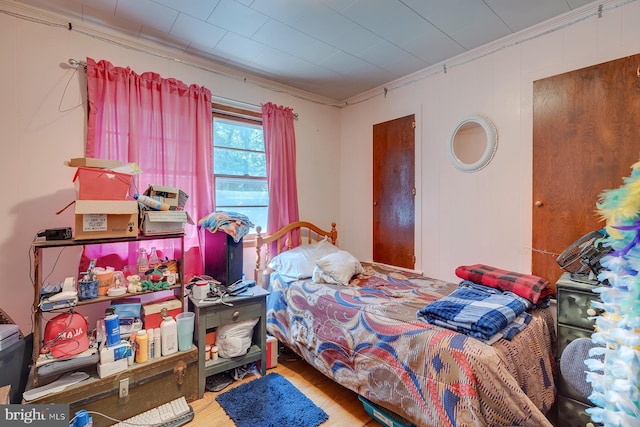 bedroom with crown molding and wood-type flooring