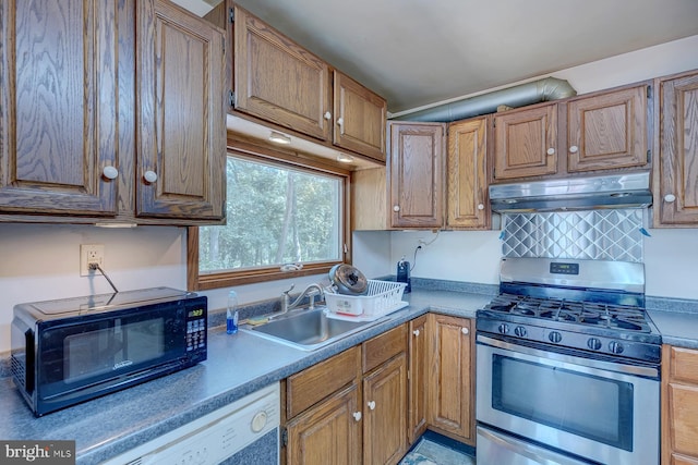 kitchen featuring stainless steel gas range oven, under cabinet range hood, a sink, black microwave, and dishwasher