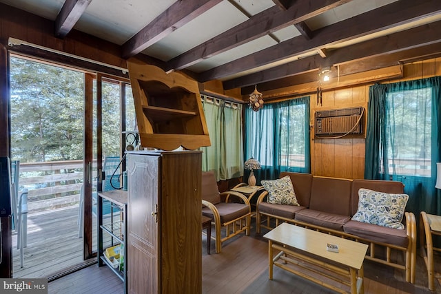 living room with wood-type flooring, wooden walls, beam ceiling, and a wall mounted air conditioner