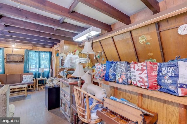 basement featuring hardwood / wood-style floors, wood walls, and an AC wall unit