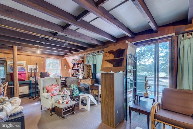 living room with wood walls, hardwood / wood-style floors, and beamed ceiling