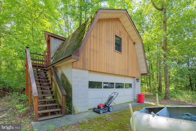 view of property exterior featuring a garage and a deck