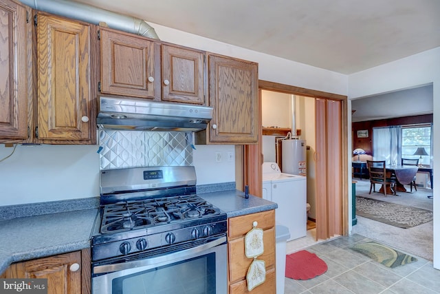 kitchen featuring gas water heater, light tile patterned floors, gas range, separate washer and dryer, and tasteful backsplash