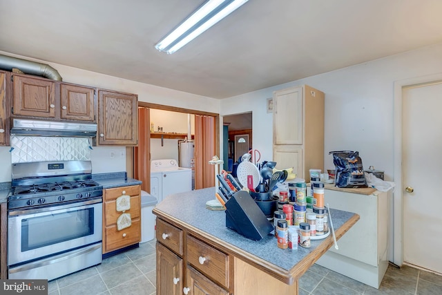 kitchen with gas range, water heater, washer and dryer, and tasteful backsplash