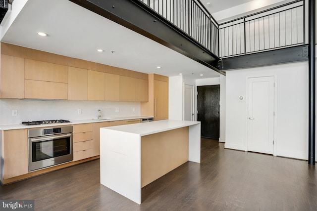 kitchen with dark wood-type flooring, appliances with stainless steel finishes, and a kitchen island