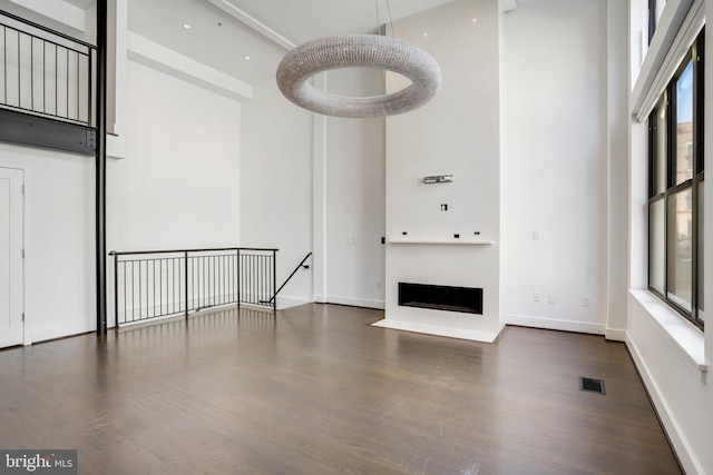 interior space with dark wood-type flooring and a high ceiling