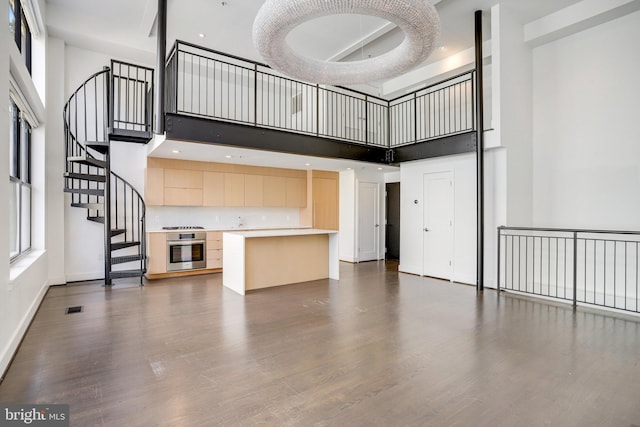 unfurnished living room with a high ceiling and dark hardwood / wood-style flooring