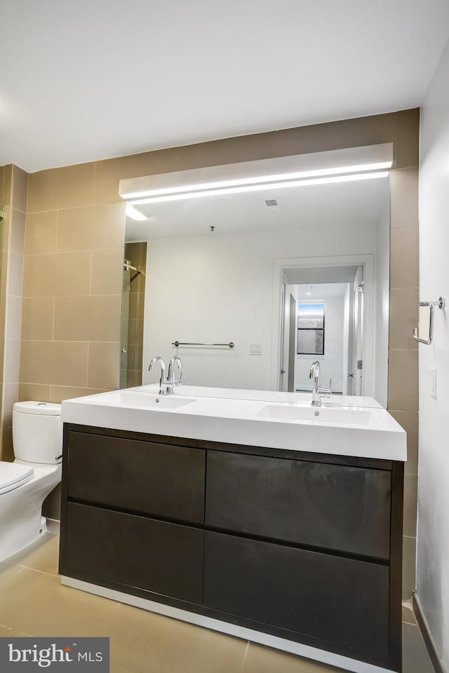 bathroom featuring vanity, toilet, walk in shower, and tile patterned flooring