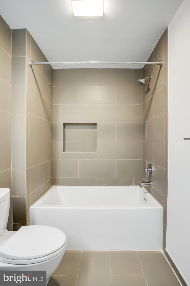 bathroom with toilet, tile patterned floors, and tiled shower / bath