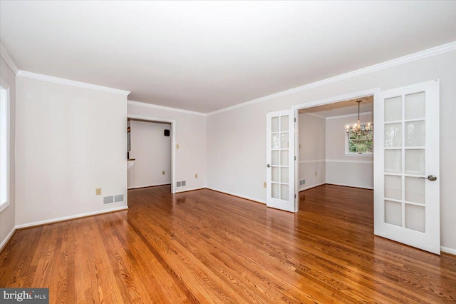 spare room featuring french doors, an inviting chandelier, and crown molding