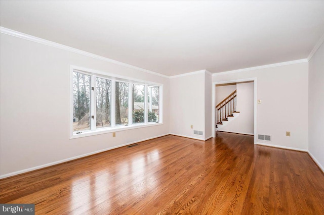 empty room featuring hardwood / wood-style flooring and ornamental molding