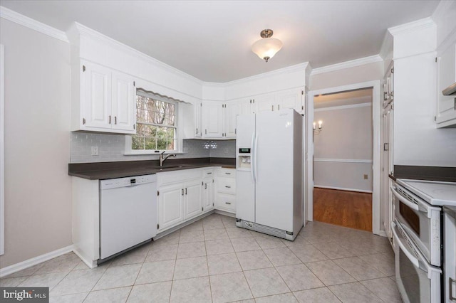 kitchen with decorative backsplash, white cabinetry, light tile patterned flooring, and white appliances