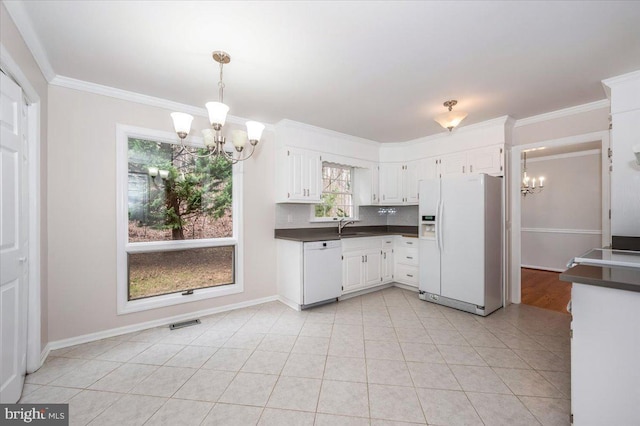 kitchen featuring white appliances, backsplash, white cabinets, ornamental molding, and a chandelier